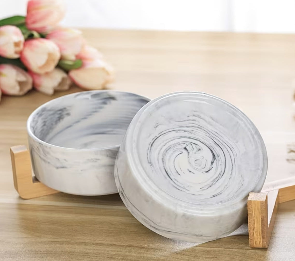 Marble ceramic pet bowls with swirl finish on bamboo rack with flowers