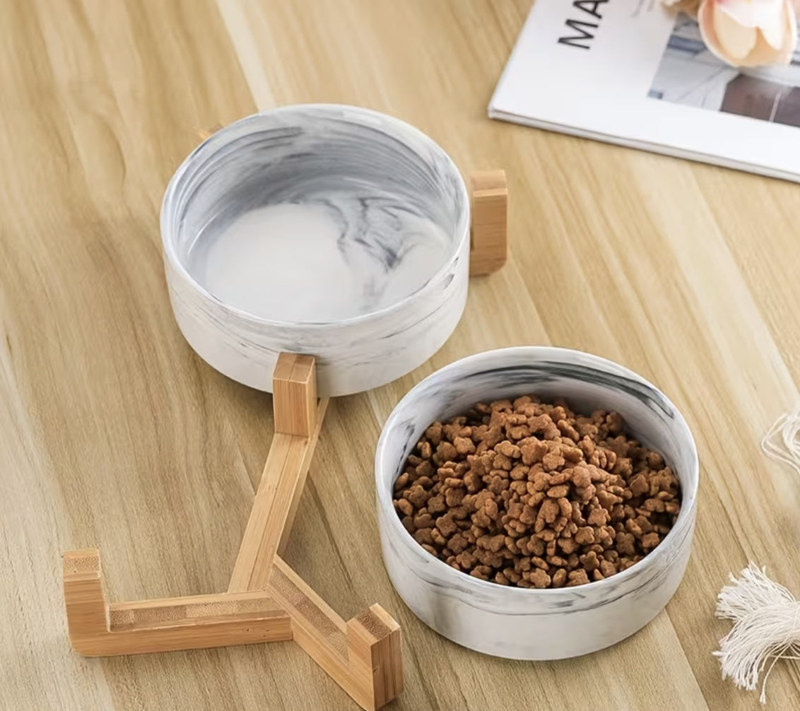 Marble ceramic pet bowls on bamboo rack with pet food